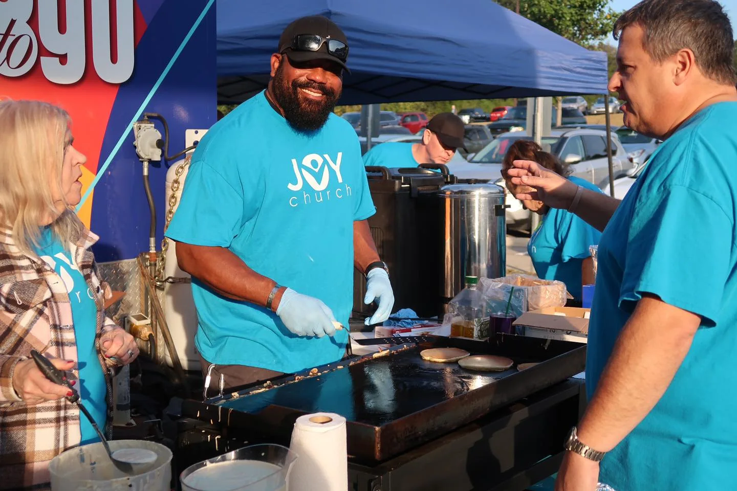 Joy To Go volunteers cooking for the community