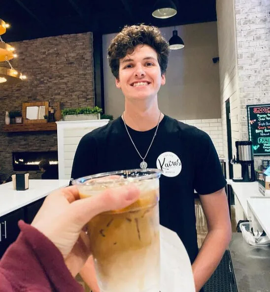 A guest raising an iced coffee at Kairos