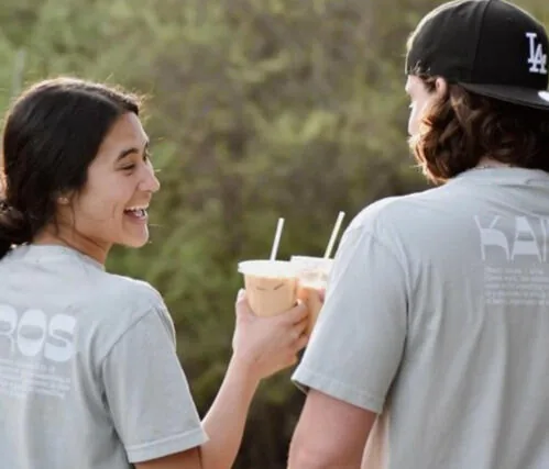 Two friends toasting Kairos cups outdoors