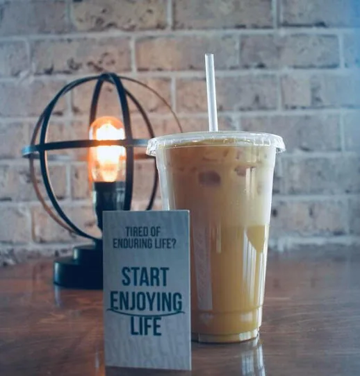 An iced coffee beside a card reading "Start enjoying life"