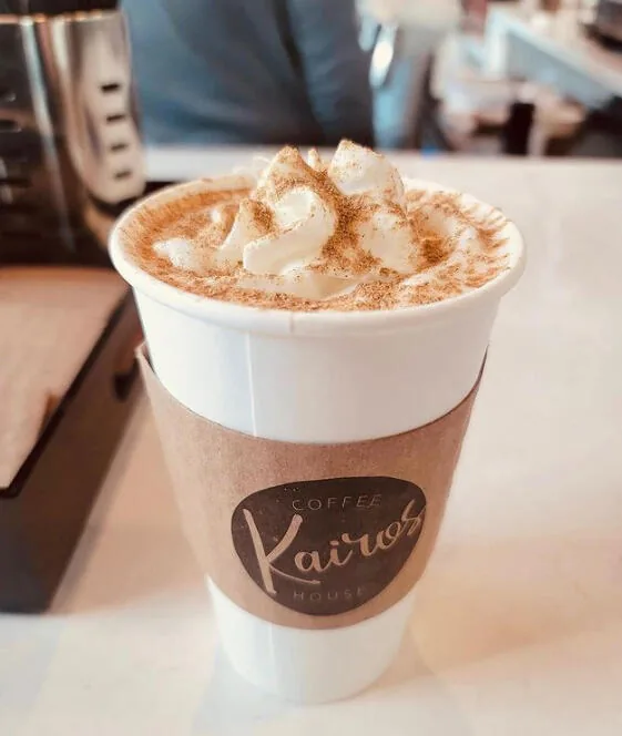 A Kairos cup topped with whipped cream