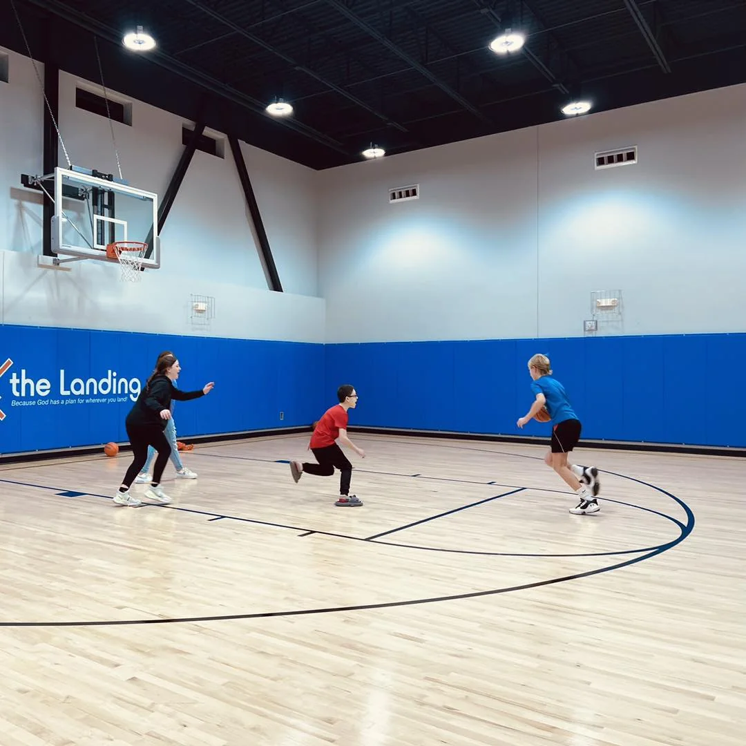 Teens playing the basketball arcade game