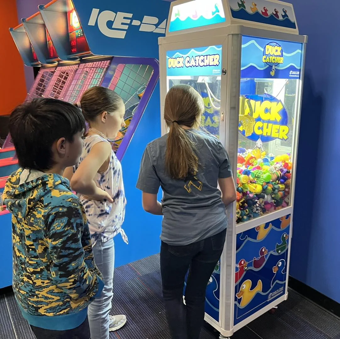 A child playing the duck catcher game at a Landing event