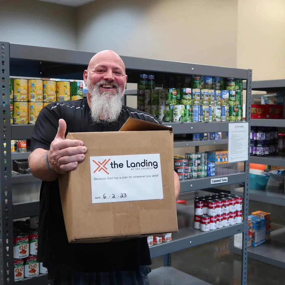 A volunteer carrying a packed food box