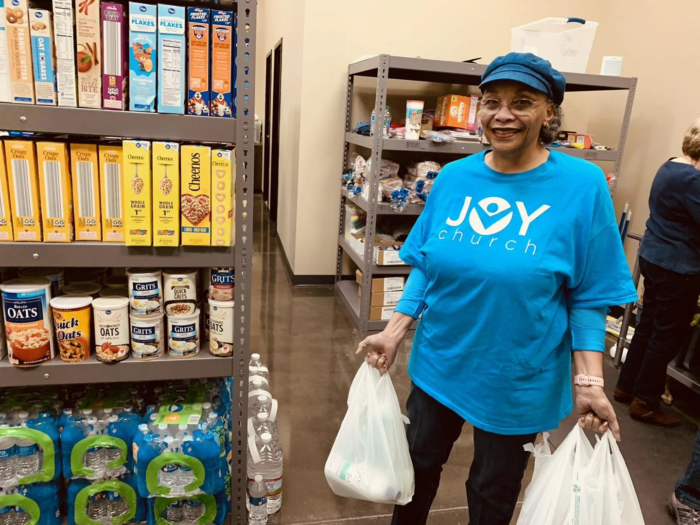 A volunteer carrying bags of groceries at The Pantry