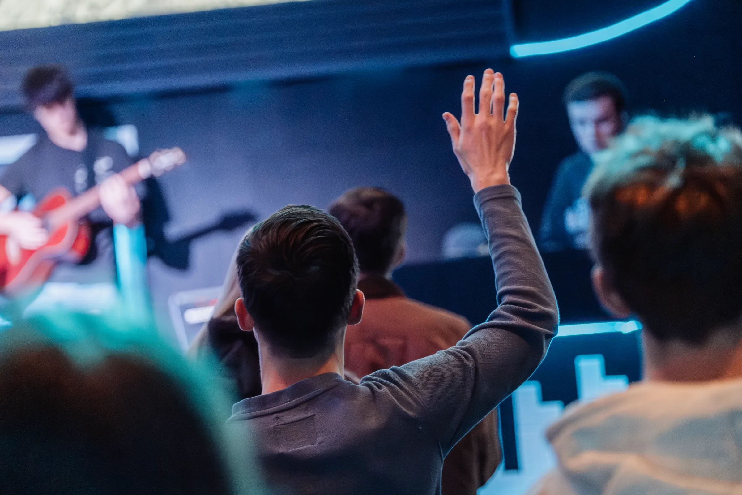 A student worshipping with hand raised