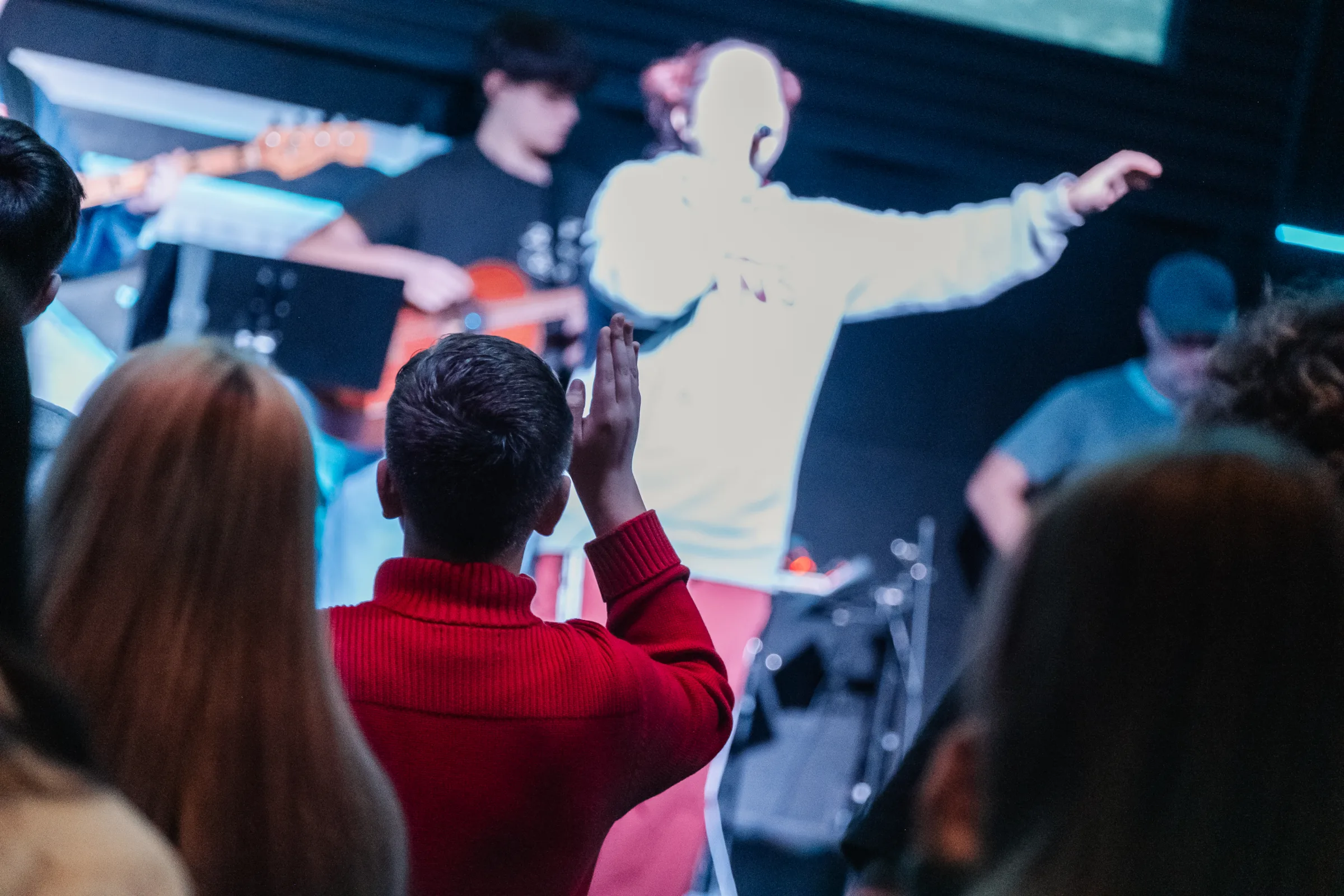 Students worshipping under the stage lights